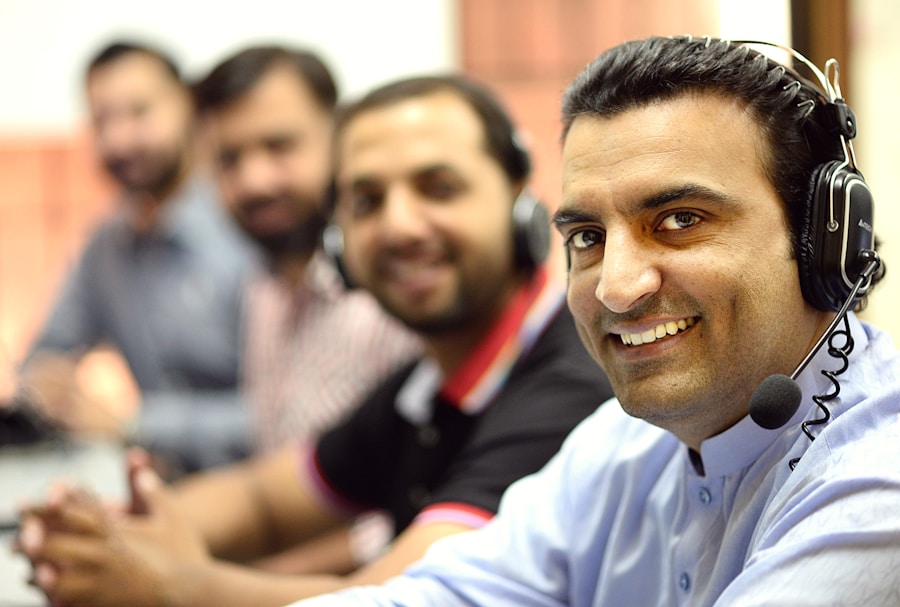 Smiling Limitise outbound sales agent wearing a headset with his team behind him
